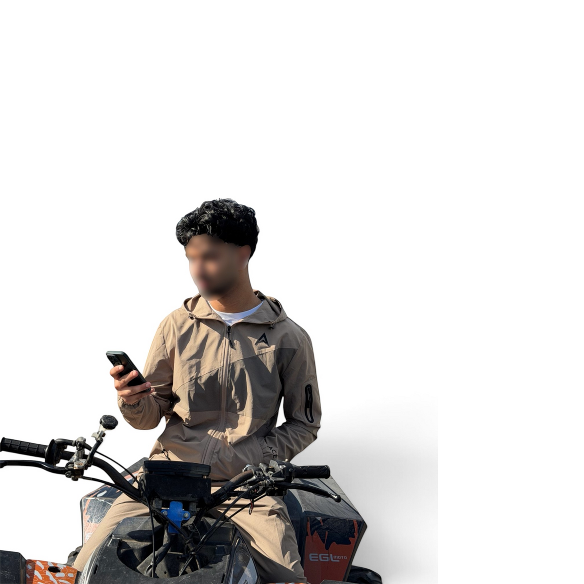 A person wearing a beige hooded jacket and matching pants sits on a red and black quad bike, holding a smartphone against a plain white background.